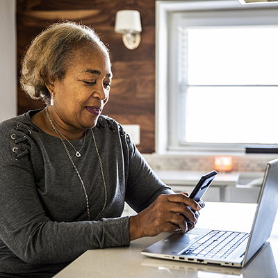 older woman on her phone and laptop