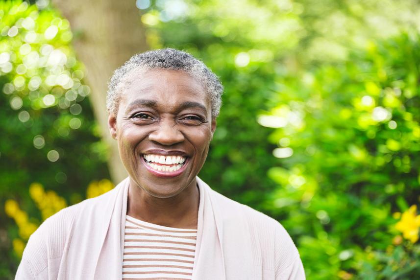 A senior woman stands outside and smiles