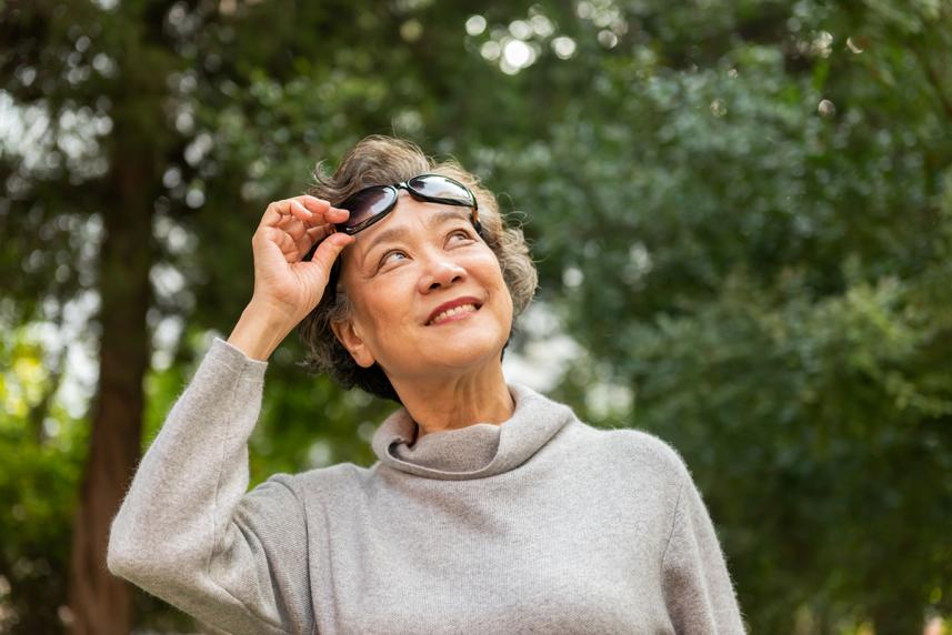 A senior woman on a walk outside wearing sunglasses