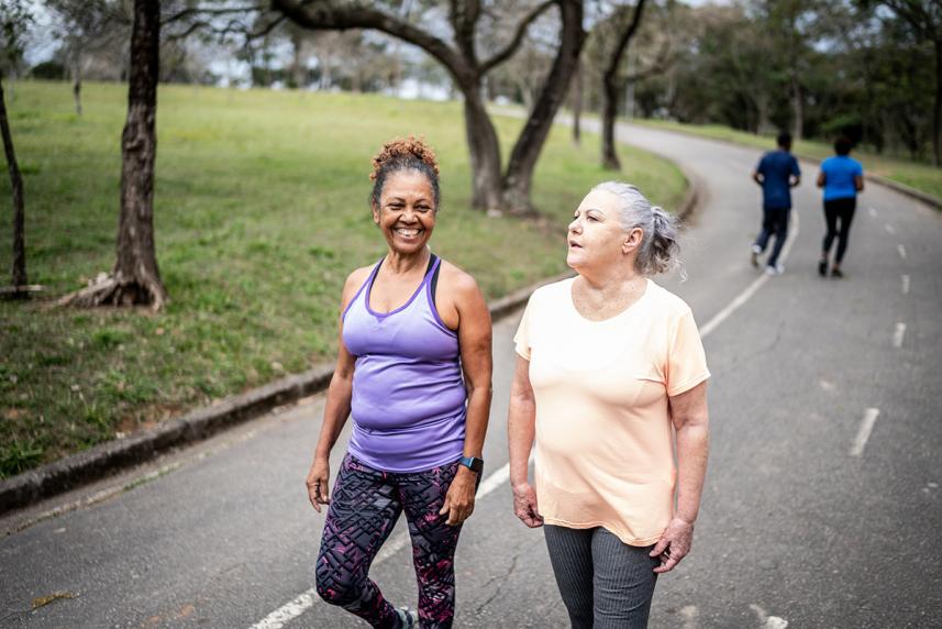 Two seniors walk on a paved path