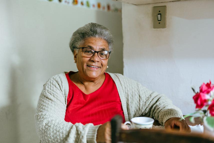 An elder drinks out of a mug