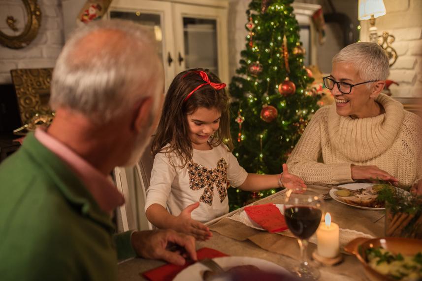 a grandchild eats christmas dinner with her grandparents