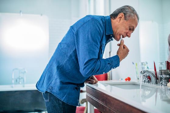 A senior brushes teeth