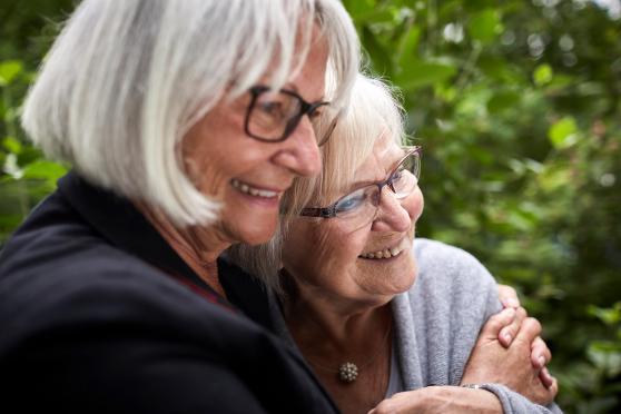 Two women holding each other, smiling